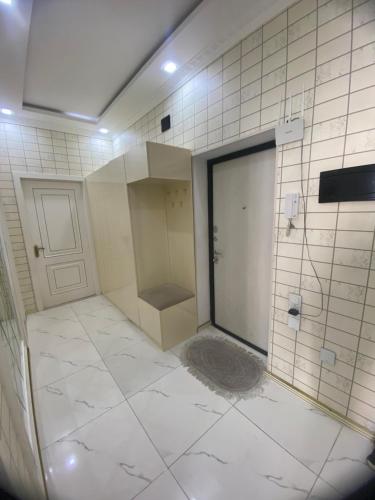 a tiled bathroom with a shower and a door at The Best Apartment in Baku