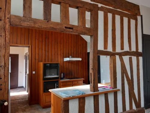 une chambre avec un lit en bois et une télévision dans l'établissement Gîte grande famille Alisiers, à Lailly-en-Val