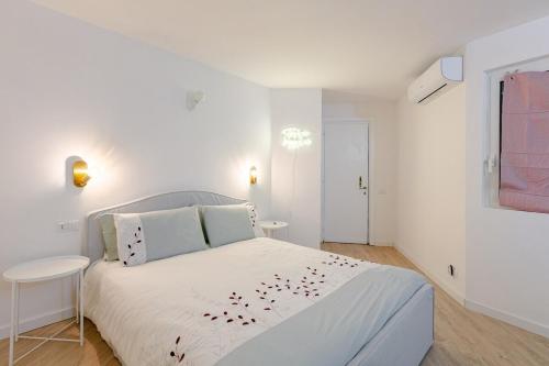 a white bedroom with a white bed and a table at La Piccola Luxury Suite in Rome