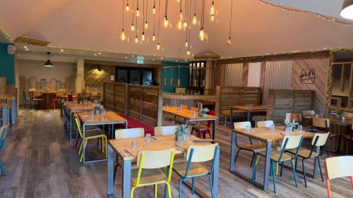 a dining room with wooden tables and chairs at Rustic Fawn Lodge with Hot Tub for 4 - Resort Spa in Devon in Chudleigh