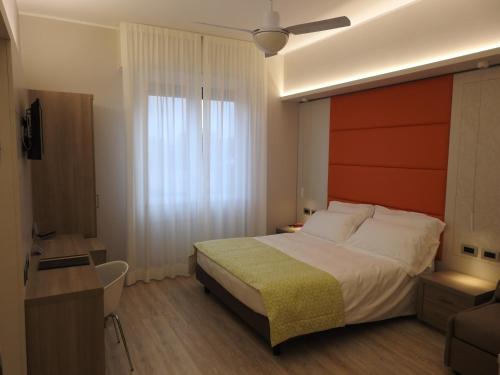 a bedroom with a bed and a desk and a window at Hotel Zurigo in Varazze
