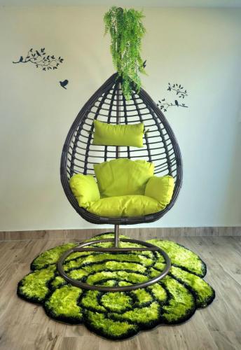 a bird cage chair on a rug in a room at Dream Island Condo in Buccoo
