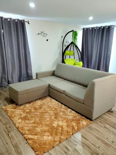 a living room with a couch and a rug at Dream Island Condo in Buccoo