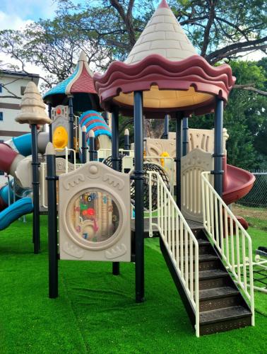 a playground with a slide on the grass at Dream Island Condo in Buccoo