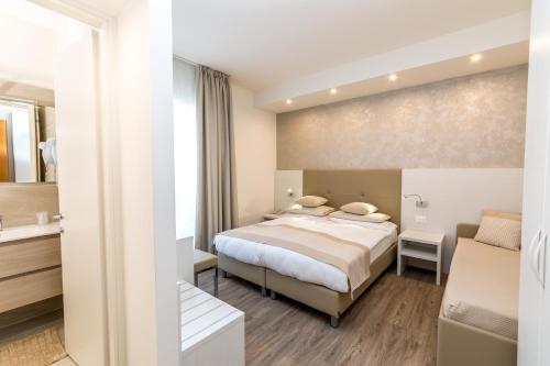 a hotel room with a bed and a bathroom at Hotel Touring in Lido di Jesolo