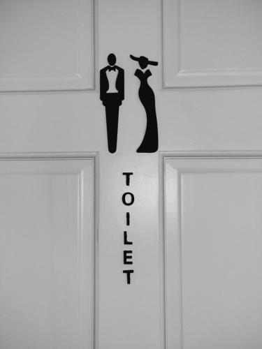 a door with a sign with a man and a woman at Dream Island Condo in Buccoo
