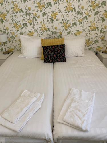 a bed with white sheets and towels on it at Pensionat Haga Öland in Löttorp