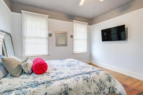 a bedroom with a bed and a tv and windows at 1 Mi to Dtwn Welcoming Macon Home with Yard in Macon