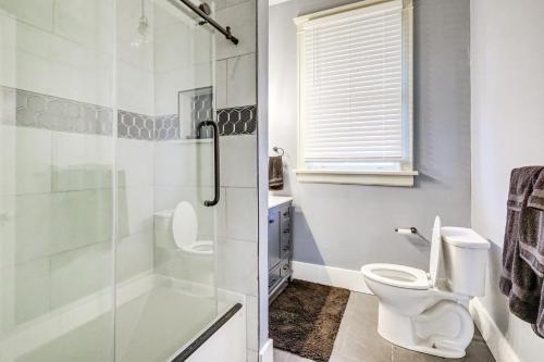 a bathroom with a toilet and a glass shower at 1 Mi to Dtwn Welcoming Macon Home with Yard in Macon