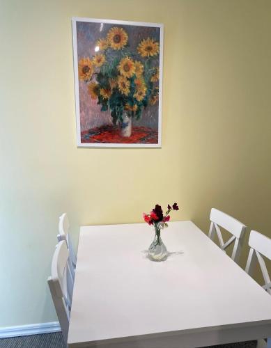 a white table with a vase of flowers on it at Pensionat Haga Öland in Löttorp