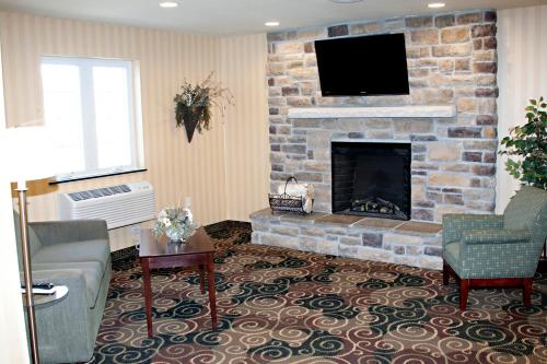 a living room with a fireplace with a flat screen tv at Cobblestone Inn & Suites - Langdon in Langdon