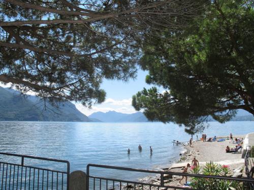 a beach on a lake with people in the water at Apartment Piazza San Giuseppe-6 by Interhome in Acquaseria