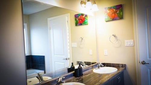 a bathroom with two sinks and a large mirror at Stunning fully furnished detached house 4 Bed Retreat, with complete privacy and comfort, WiFi & Full Kitchen in Paris