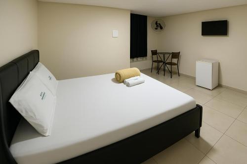 a bedroom with a large bed with a chair on it at Hotel Veneza in Brasília