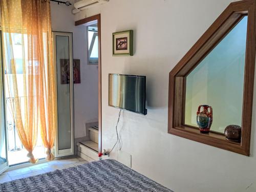 een slaapkamer met een spiegel en een tv aan de muur bij Holiday Home RomaMia by Interhome in Mola di Bari