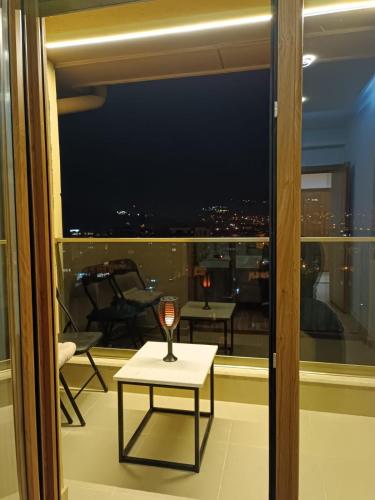 a wine glass sitting on a table in front of a window at Sky View Apartment in Novi Pazar