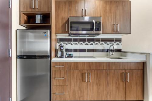 a kitchen with a stainless steel refrigerator and a microwave at Best Western Plus Hinton Inn & Suites in Hinton