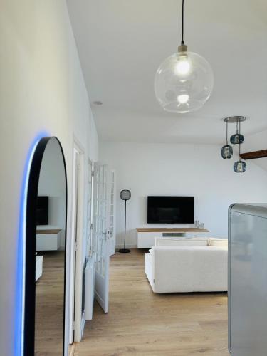 un salon blanc avec un canapé blanc et une télévision dans l'établissement Appartement Jules Ferry - centre, à Saumur