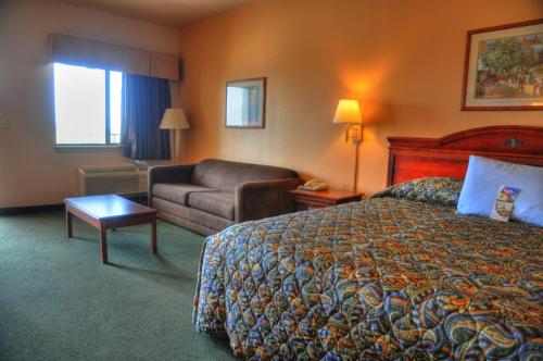 a hotel room with a bed and a couch at Lone Star Inn and Suites Victoria in Victoria