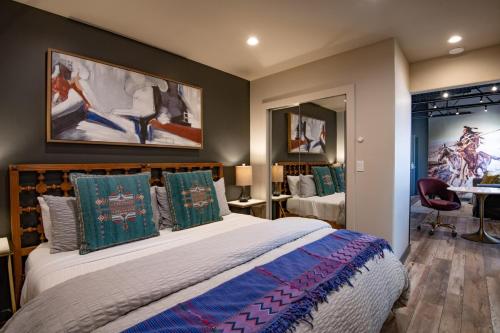 1 dormitorio con 1 cama grande con almohadas verdes y azules en Designer Loft at the Santa Fe Plaza Spacious 520 Sq Ft, King Bed, en Santa Fe