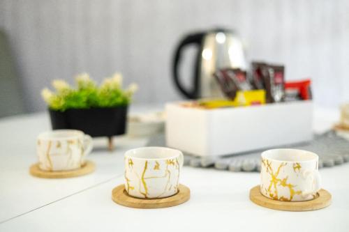 three coffee cups sitting on a kitchen counter at Apartman D&A in Brekovica