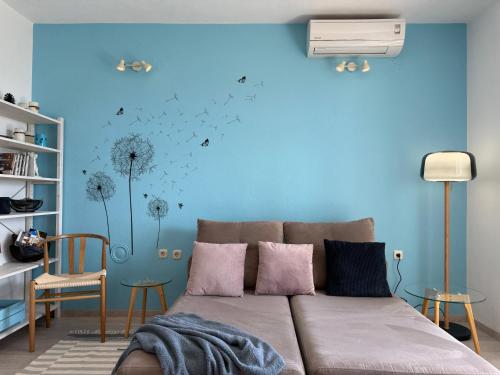 a living room with a couch and a blue wall at Apartment Chiara in Tučepi