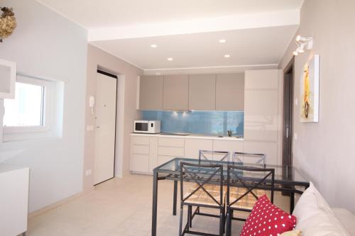 a kitchen with a glass table and chairs at Residence Il Poggio in Dorio