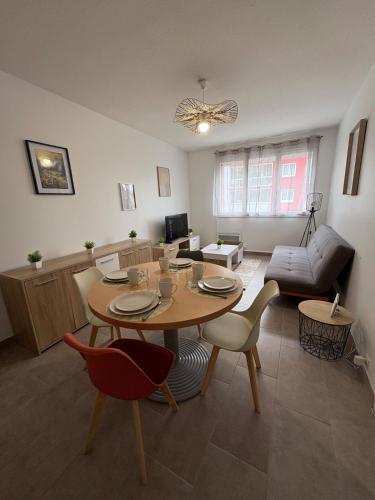 un salon avec une table, des chaises et un canapé dans l'établissement Nice tourist apartment, à Digoin