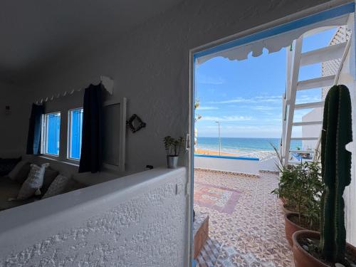a room with a view of the beach from a doorway at Afoulki Home in Taghazout