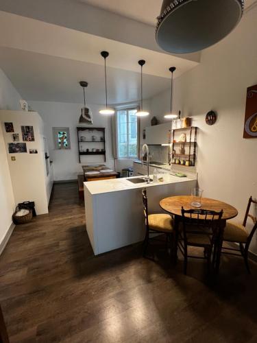une cuisine et une salle à manger avec une table et une cuisine avec un évier dans l'établissement Appartement Lafayette, au cœur du quartier Decré, à Nantes