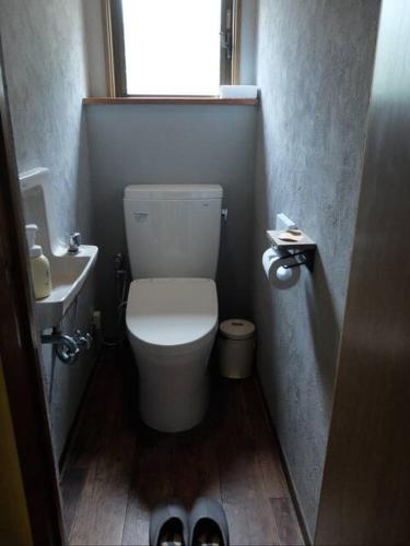 a small bathroom with a toilet and a sink at Guest House coco-Rin in Hamamatsu