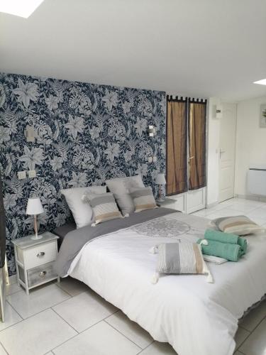 - une chambre avec un grand lit et du papier peint floral dans l'établissement Chambre La Côte Sauvage, à La Tremblade