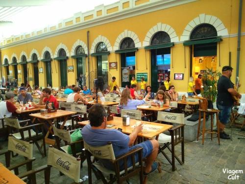 a group of people sitting at tables in a restaurant at Air-conditioned apartment - Privileged Location and Vacancy! in Florianópolis