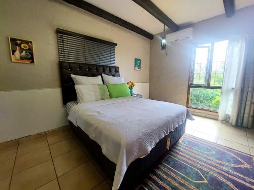 a bedroom with a large bed and a window at Daven Guest House in Pietermaritzburg