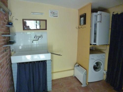 une petite cuisine avec un évier et une machine à laver dans l'établissement Roulotte, à Aubres