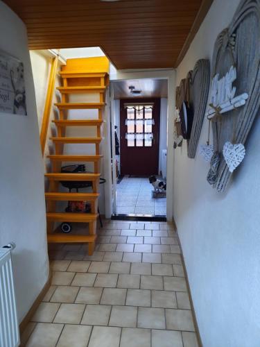 a hallway with a staircase leading to a room with a door at Ferienhaus Grietjes Huus in Krummhörn