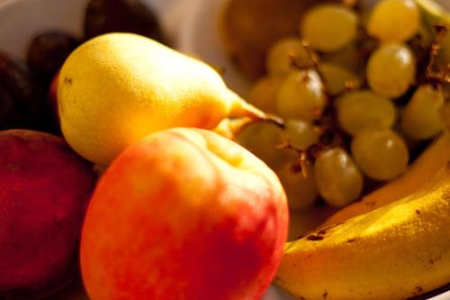 a bowl of fruit with apples bananas and grapes at Dar tal-Kaptan Boutique Maison in Għasri