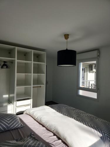 une chambre avec un grand lit et une fenêtre dans l'établissement Cocon Vaulx Village LDLC Groupama Eurexpo, à Vaulx-en-Velin