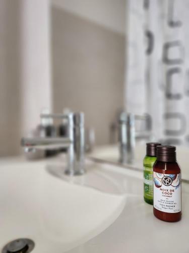 deux bouteilles de liquide buccal posées sur un lavabo de salle de bain dans l'établissement Cocon Vaulx Village LDLC Groupama Eurexpo, à Vaulx-en-Velin