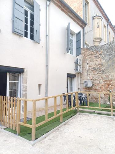 une clôture en bois devant une maison dans l'établissement Charmant T2 cosy avec sauna privé & cour en plein cœur de la ville, à Agen