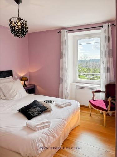 une chambre avec un lit, une fenêtre et une chaise dans l'établissement Le gîte Angèle, 12pers, piscine, calme, 4ch, 9lits, à Sénezergues