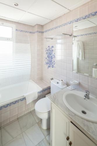 a bathroom with a toilet and a sink and a tub at Hotel Platería in Écija