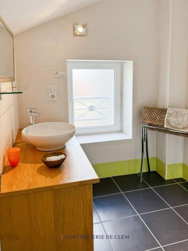 une salle de bain avec un lavabo et une fenêtre dans l'établissement Le gîte Angèle, 12pers, piscine, calme, 4ch, 9lits, à Sénezergues