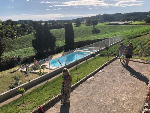 un groupe de personnes debout sur une colline à côté d'une piscine dans l'établissement Le gîte Angèle, 12pers, piscine, calme, 4ch, 9lits, à Sénezergues