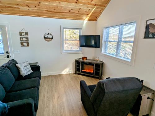 SullivanにあるAcadia Sunset Fishing Cabin #4 family beach firepitのソファと暖炉のあるリビングルーム