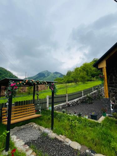 a bench in a garden with a view of a field at Woodlandia Resort Borjomi in Borjomi