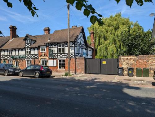 a black and white building with cars parked in front of it at A historic Pub with a modern twist - The Greyhound in Bury Saint Edmunds