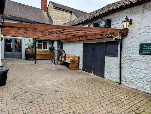 a building with a barn with a wooden roof at A historic Pub with a modern twist - The Greyhound in Bury Saint Edmunds