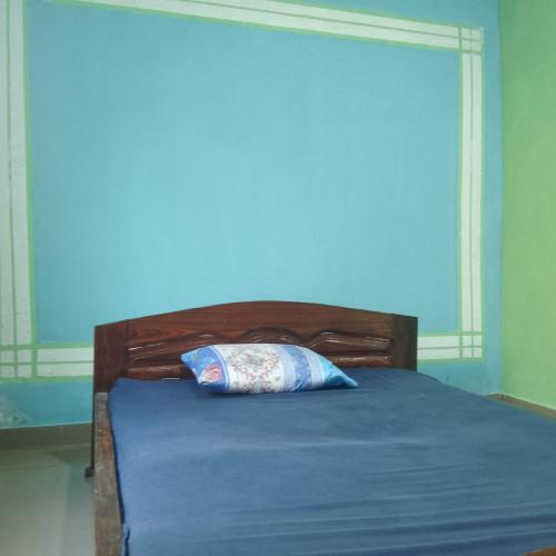 Una cama con sábanas azules y una almohada. en La Villa N'goki, en Pointe-Noire