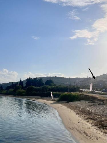 a sandy beach with a body of water at Nea Peramos Apartment SeaFront in Néa Péramos
